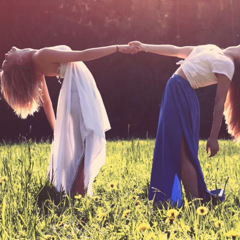 Dos mujeres en un campo de flores - ritual de sembrar la luna con sangre menstrual